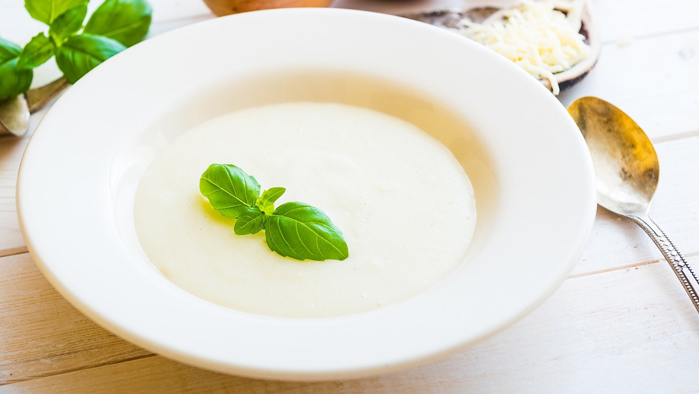Cream of onion soup bowl with basil