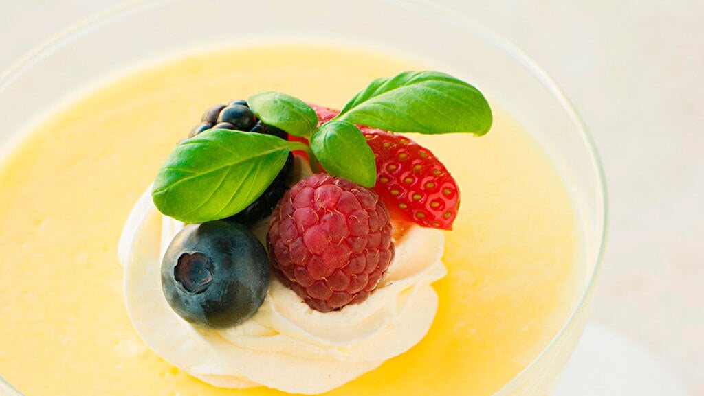 Lemon ginger pudding topped with cream and berries