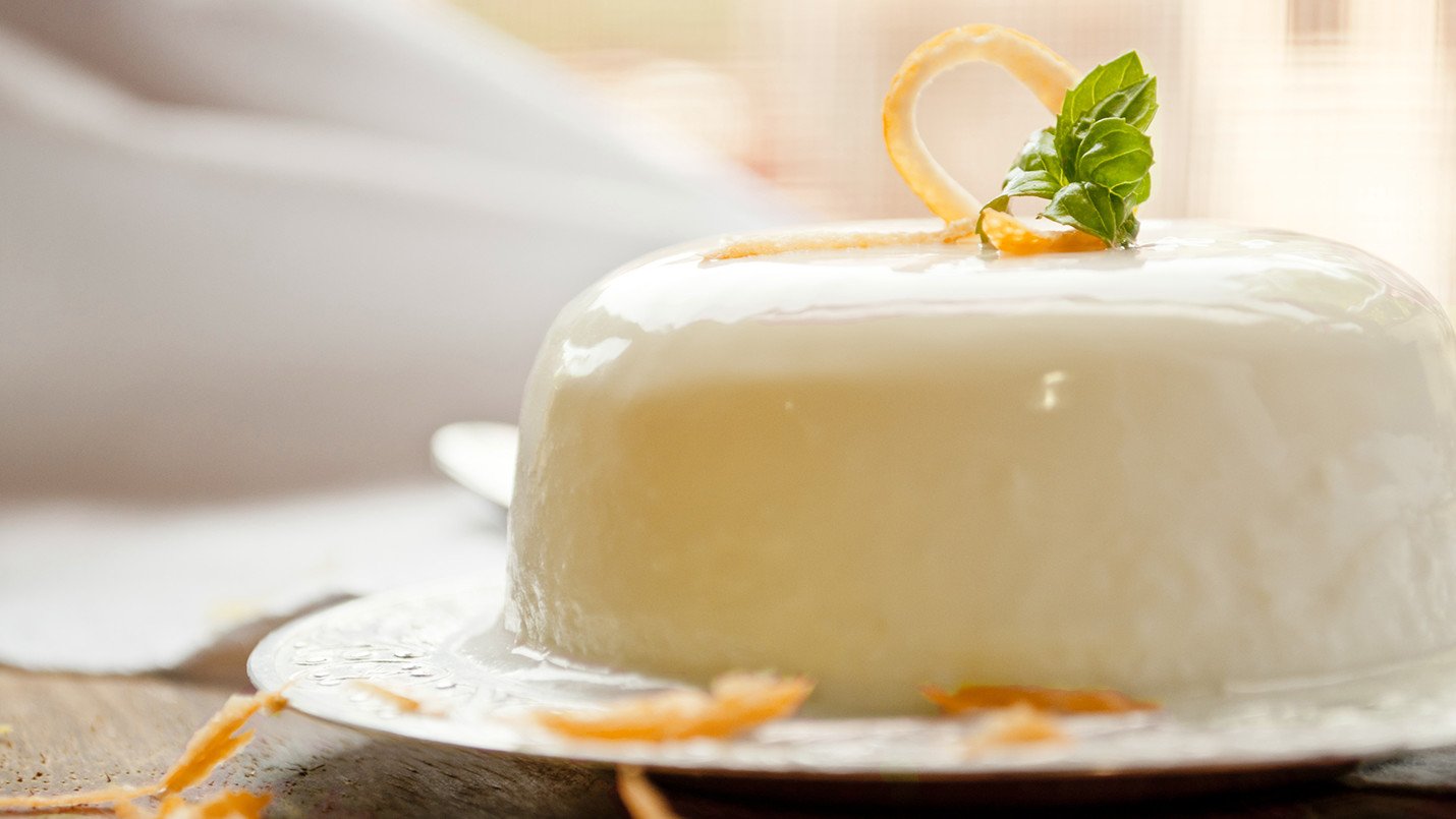 Glazed orange panna cotta cake on white plate
