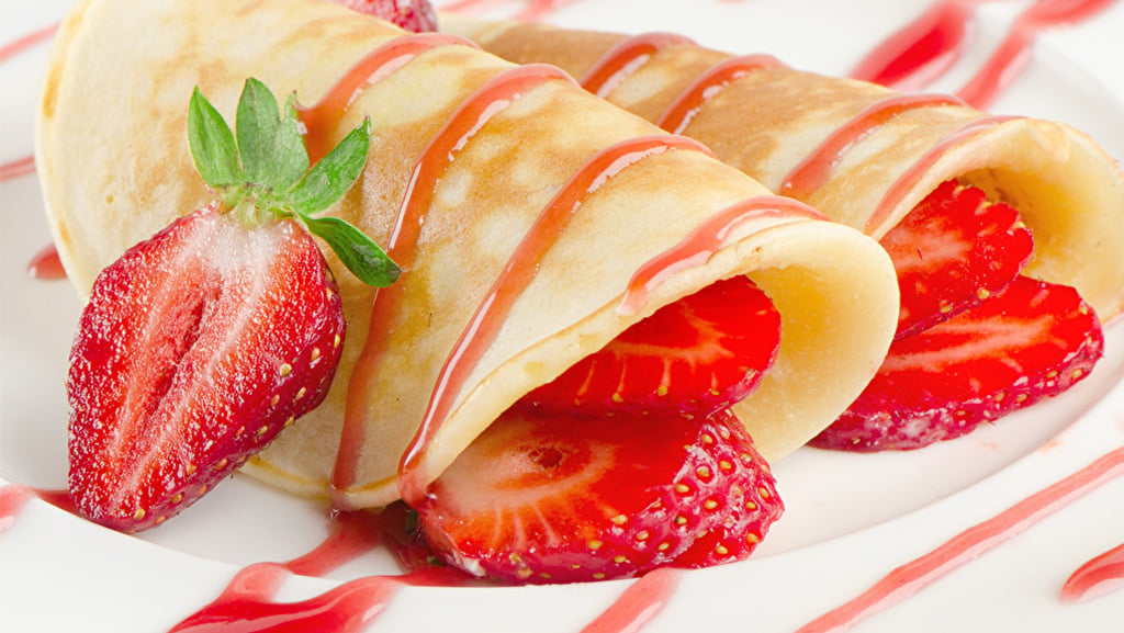 Sweet strawberry dessert crepes with strawberry sauce