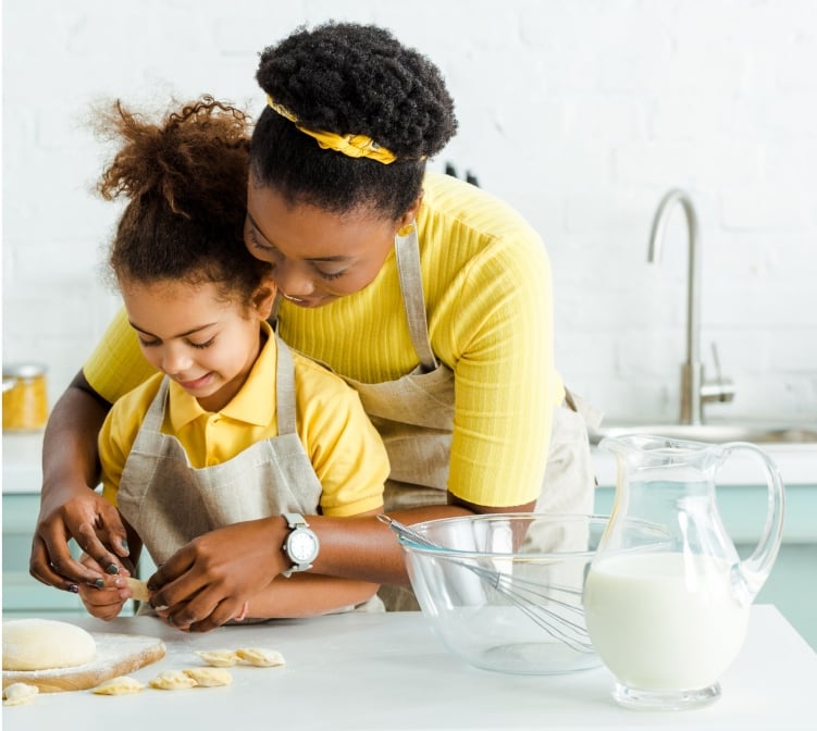 Woman and child baking with pitcher of milk