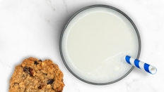 Glass of LACTAID® Protein Milk and cookie on marble counter