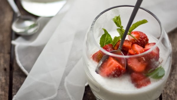 Lactose-free milk pudding topped with strawberries and mint